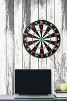 Laptop mockup with a dartboard on a wooden wall