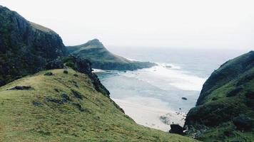 Green mountains near seashore photo