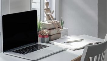 espacio de trabajo con una computadora portátil y suministros en una mesa foto