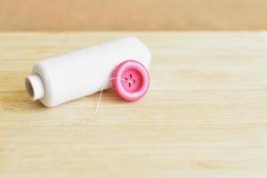 Pink button and white thread photo