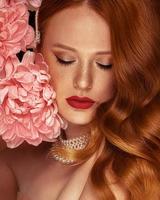 mujer con pelo rojo y flor foto