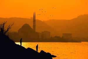 Silhouette of two people near the sea  photo