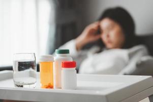 frascos de medicamentos con un vaso de agua foto