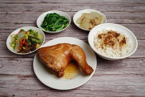 pollo al horno con arroz y guarniciones de verduras foto