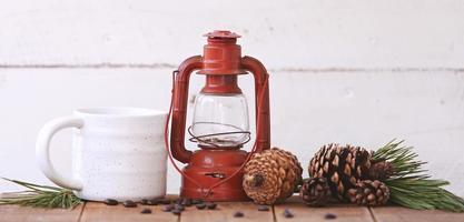 Lantern and a coffee cup with pinecones photo