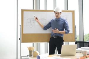 Male engineer in hard hat discussing blueprints photo