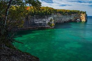 Green ocean near rocky coast photo