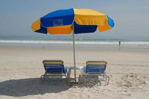 sillas de playa y sombrilla foto