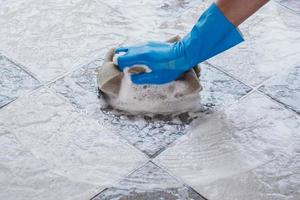Close-up of a person cleaning a floor with a sponge photo