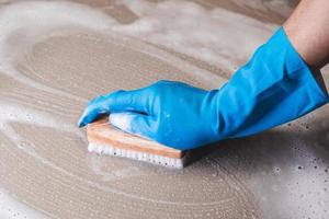 Close-up of a person cleaning a surface with a brush photo