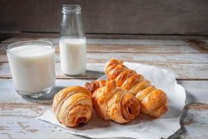 panecillos recién hechos con un vaso de leche foto