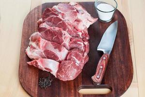 Raw pork chops. Arrangement on a cutting board. photo