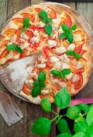Rustic pizza topped with fresh basil leaves