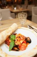 Seafood pasta cooked under pizza dough leaf photo