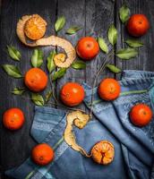 Mandarinas con hojas sobre fondo azul de madera rústica foto