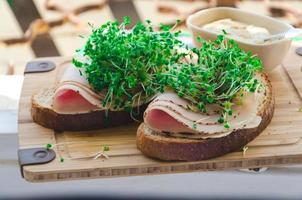 Broccoli sprouts with ham and rye bread, mustard photo