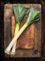 fresh Leek  on cutting board and  wooden table , top view