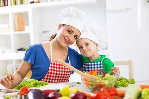 encantadora madre e hijo dos chefs en la cocina foto