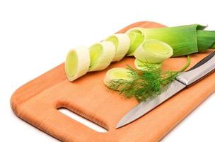 Fresh sliced leek and dill on a wooden board photo