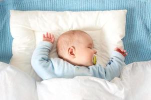 Four month old baby sleeping on blue blanket