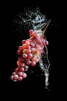Bunch of grapes with water splash against black background photo