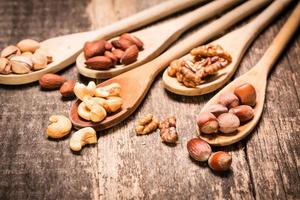 mezclar nueces en la mesa de madera, comida vegana saludable.