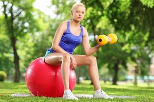 mujer joven, ejercitar, con, un, pesa, y, pelota de pilates foto