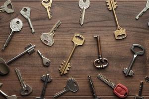 many different keys on wooden table photo