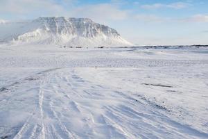 paisaje invernal con montañas, nieve y pequeñas casas de campo, islandia