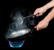 Chef cooking with flame in a frying pan