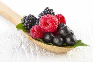Forest berries in wooden spoon photo