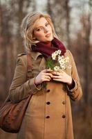 Young woman with a flowers in autumn forest photo