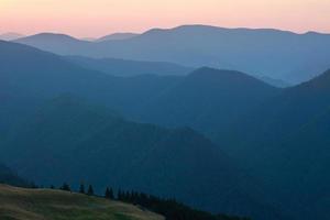 Mountain forest on ridge at dawn sky background photo