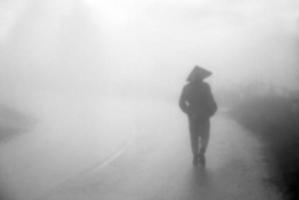 blur man walk into the misty foggy road,dark atmosphere photo