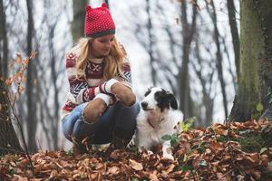 Young woman and her dog posing outdoor in the forest photo