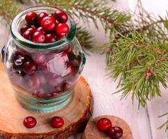 organic cranberries in the northern forest container on natural wooden photo