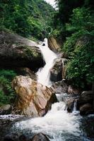 Waterfall and rock pond in rainforest photo