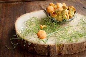 chanterelles with chili pepper and dill on a wooden table photo