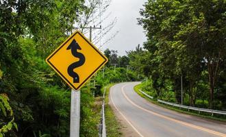 Curvy road sign to the mountain in rural area