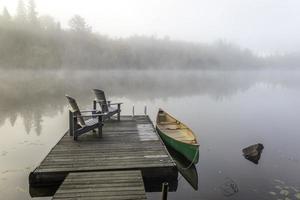 Green Canoe and Dock on a Misty Morning