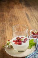 Healthy breakfast cup of fresh milk yoghurt with wild strawberries photo