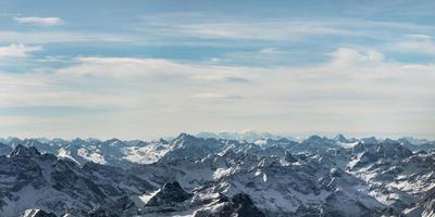 Picos de montañas nevadas rocosas en Austria con azul cielo nublado