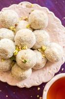 Homemade coconut balls decorated with little pink flowers photo
