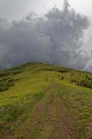 Trail on the mountain top and stormy sky.