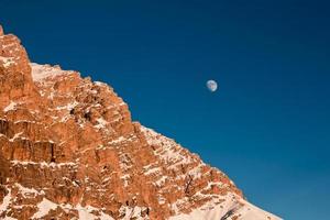moon rising behind the mountain photo