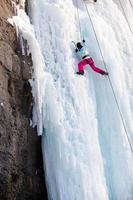 Woman climbing frozen waterfall photo
