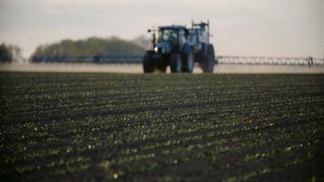 traktorspray gödsla på fält med kemikalier i jordbruksfält. video