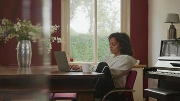 mujer madura, usar la computadora portátil, en casa