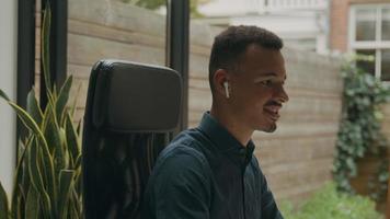Young man wearing ear phones talking in online meeting video