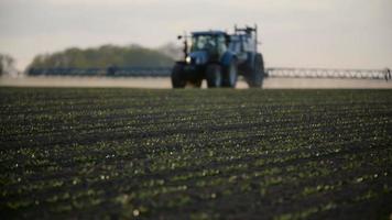 trator pulverizador fertilizar no campo com produtos químicos no campo da agricultura. video